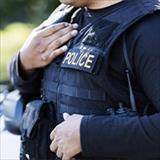 A close up shot of a police officer wearing his tactical vest.