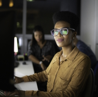 Woman with glasses sitting at her desk 