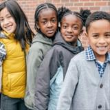 School children stand in a line outside of the school
