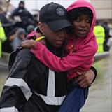 Police officer carrying girl