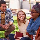 Three teenage friends laughing outside.