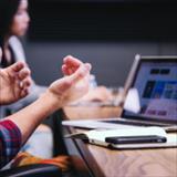 Man's hands gesturing in front of computer