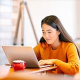 Young woman using laptop comfortably at home