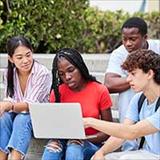 diverse college students looking at laptop computer