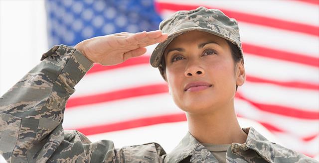 female army soldier saluting with the American flag in background