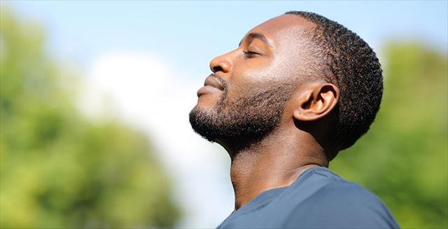 Black man breathing fresh air in nature