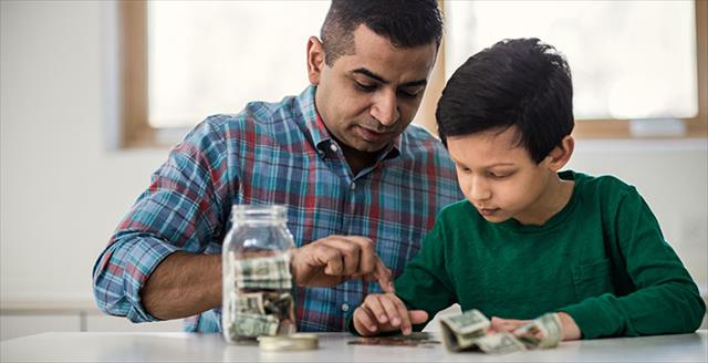 father and son counting money at home