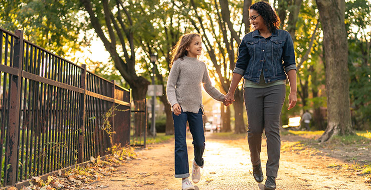Menina e mãe andando por um parque