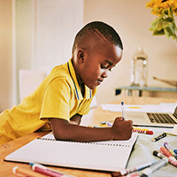 Young boy writing in notebook