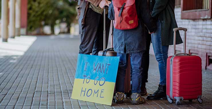Ukrainian family standing in a group with luggage