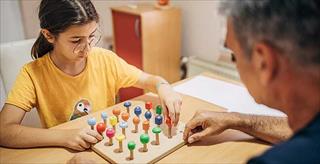 therapist and young client playing a game