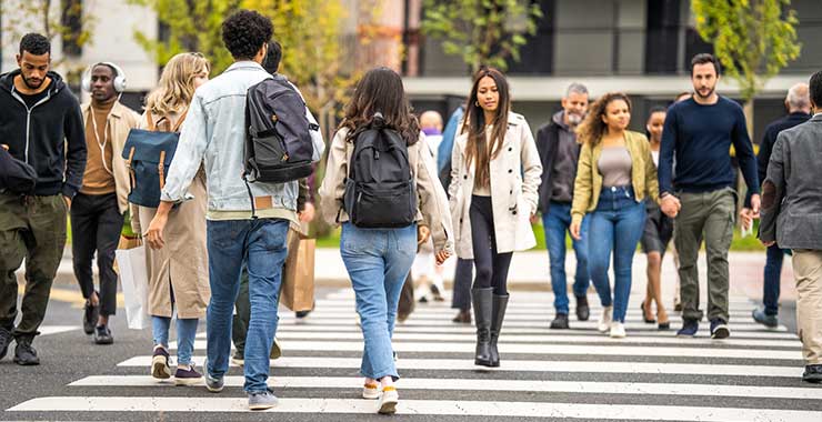 people walking across a street in a crosswalk