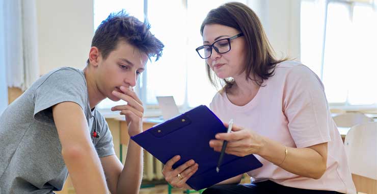 woman with a smart tablet talking with a teenager