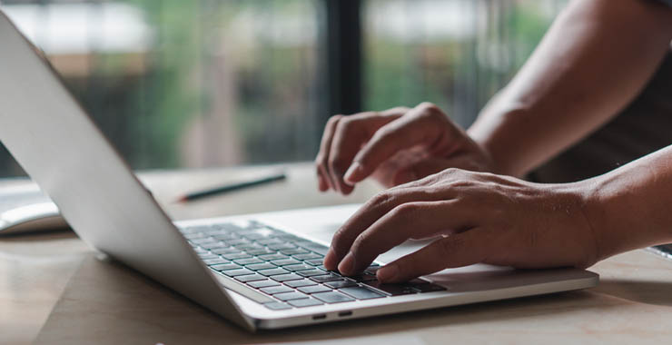 A generic image of hands typing on a laptop