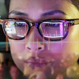 reflection of computer screen on a woman’s face