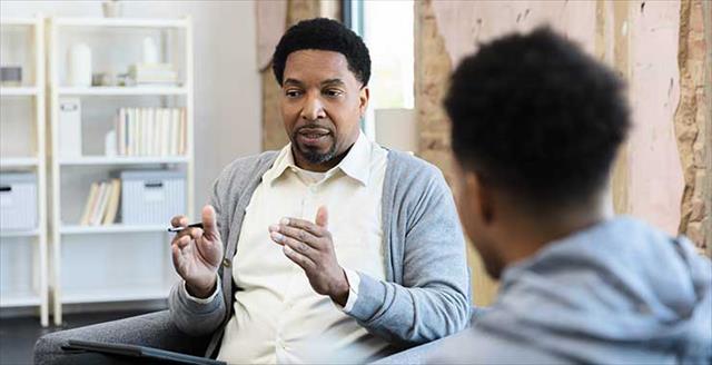therapist gestures while talking to his patient to provide some advice and guidance