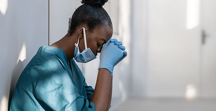 exhausted medical worker kneeling in a hallway