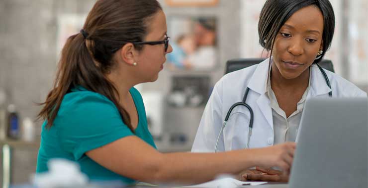 two women professionals in a medical setting having a conversation