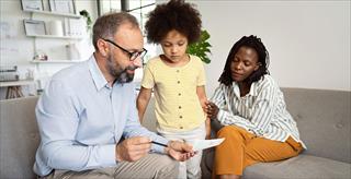 male psychologist reviewing test results with young Black girl and her mother