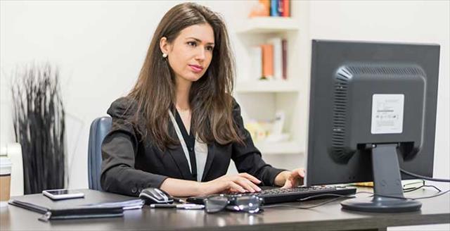 Woman in an office setting looking at computer screen 