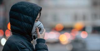 person walking outside with an air filter mask over their face