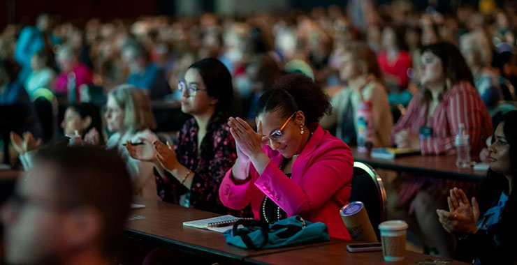 Woman clapping in the audience at APA 2026