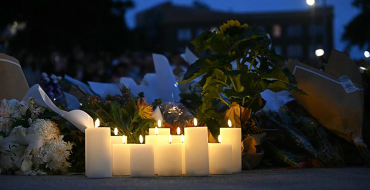 Lit candles placed in front of a memorial to honor the victims of the Bondi Beach tragedy in Australia.