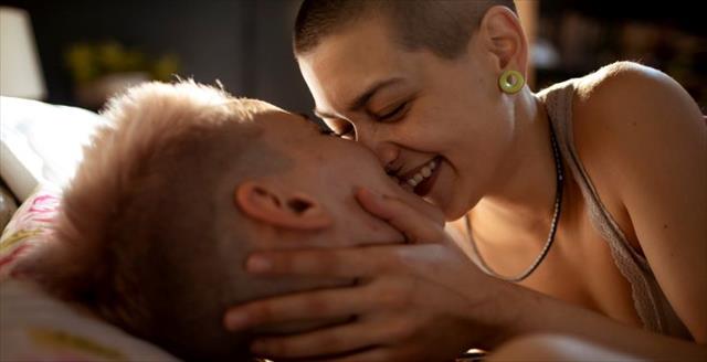 Young female couple waking up in bed.