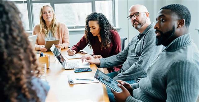 Group of staff around table at business meeting