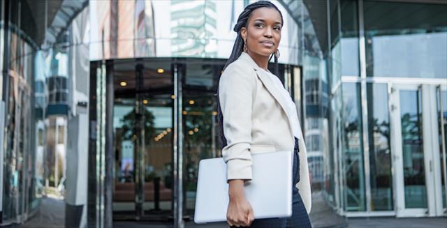 Professional young woman in front of building