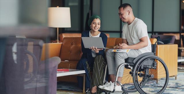 Man in wheelchair talking to woman