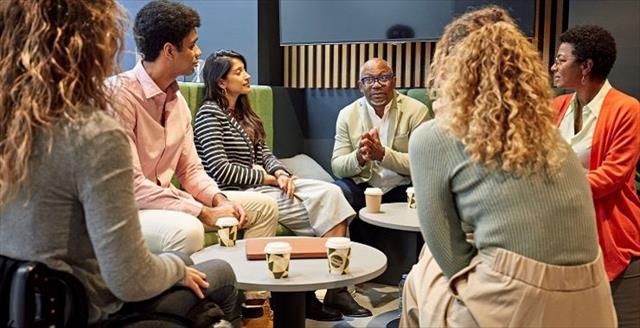 Diverse group of older and younger professionals networking during an informal meeting.