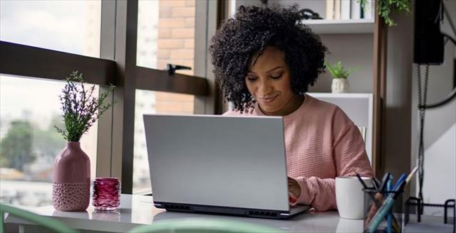 Woman completing application on laptop.