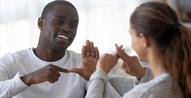 African American man and woman converse using American Sign Language.