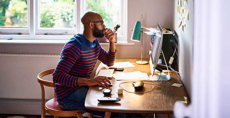 Man sitting at a desk, using a computer
