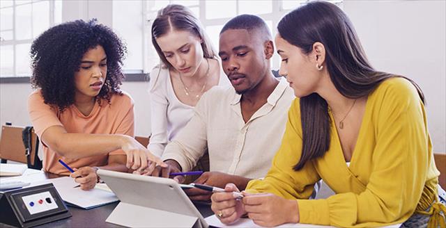 A group of students looking at laptop