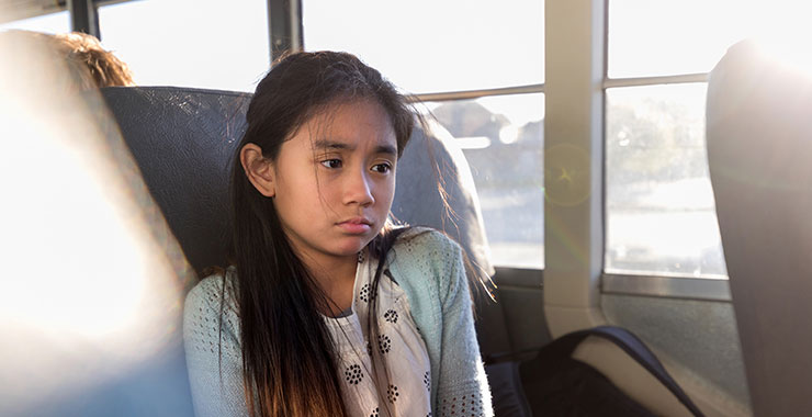 On school bus, young girl is sad