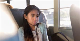 On school bus, young girl is sad
