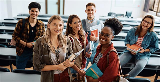 Small group of ethnically diverse college students smiling at camera.