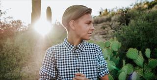 person in neutral dress shirt standing outside