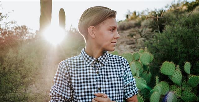 person in neutral dress shirt standing outside
