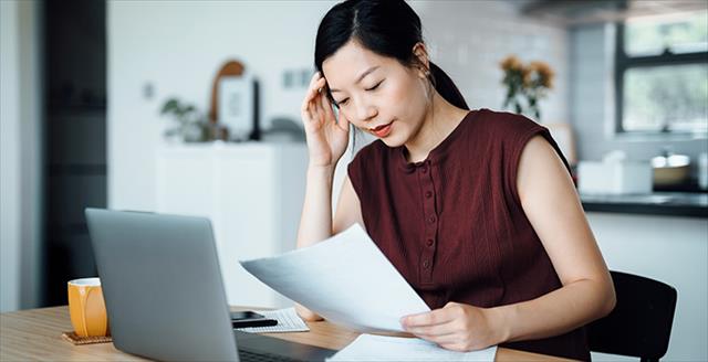 person sitting at desk reviewing paper report