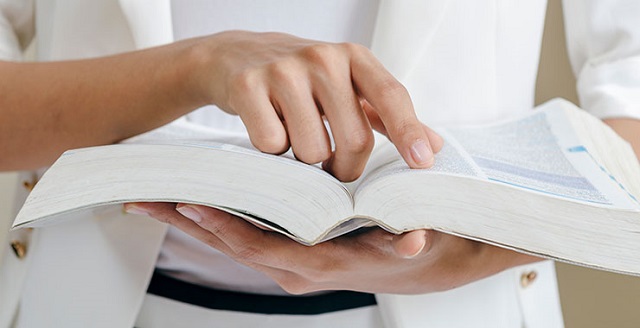 Person reading through textbook