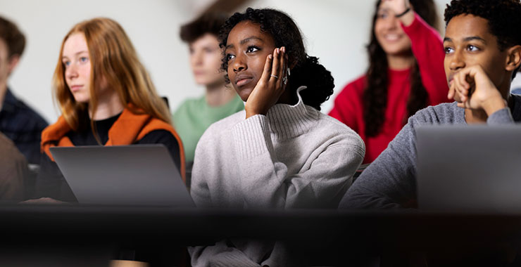 Female student listens to teacher lecture.