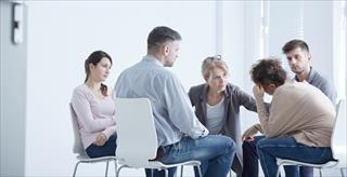 Group of people consoling a man