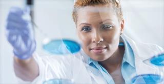 Person in a lab examining a test tube
