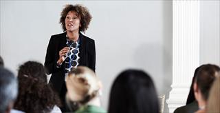 person speaking to a group of seated people