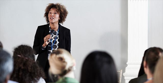 person speaking to a group of seated people