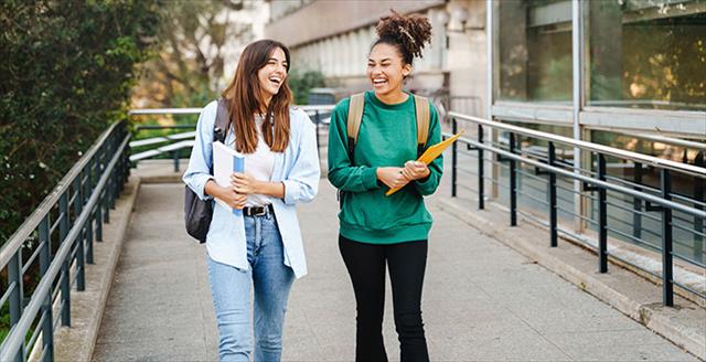 Two female students walk together on campus.