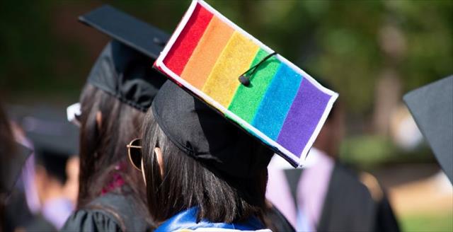 Graduating student with rainbow colors painted on graduation cap